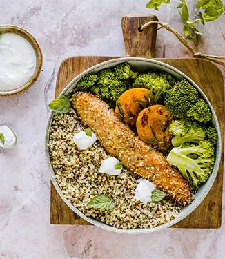 Warm quinoa bowl with sesame-coated salmon and apricots