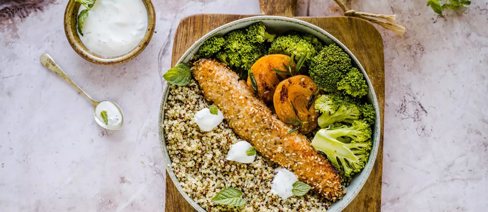 Warm quinoa bowl with sesame-coated salmon and apricots