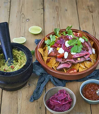 Loaded nachos with guacamole and salsa